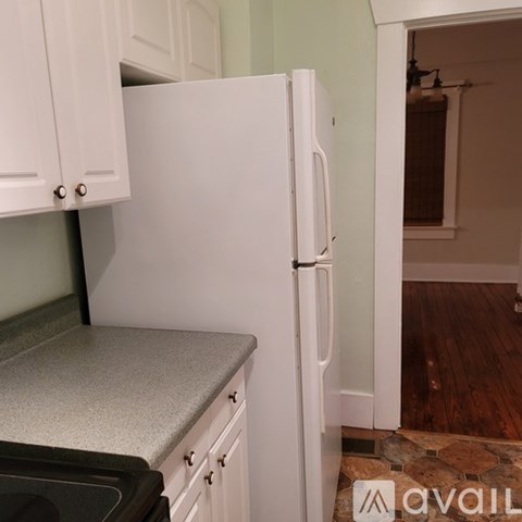 A white refrigerator in a kitchen with a granite countertop.