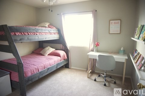 A bedroom with a bunk bed and a desk.