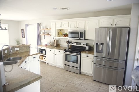 A kitchen with white cabinets and stainless steel appliances.