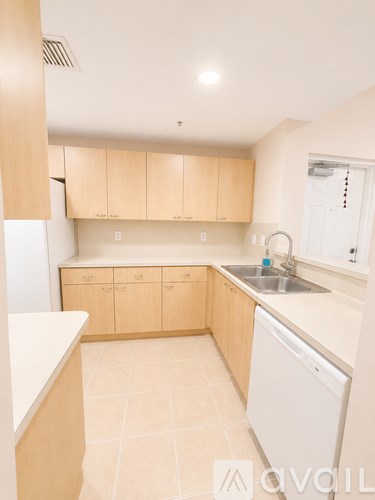 A kitchen with wooden cabinets and a white dishwasher.