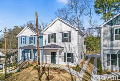 A white house with a blue trim is for sale.