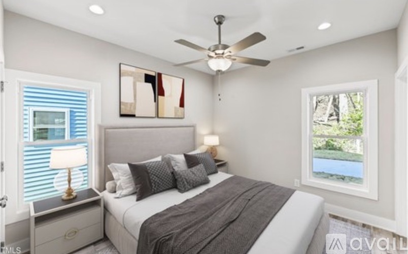 A bedroom with a bed, a ceiling fan, and a window with blinds.
