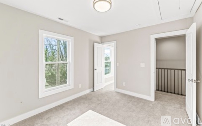A spacious room with a doorway leading to another room.
