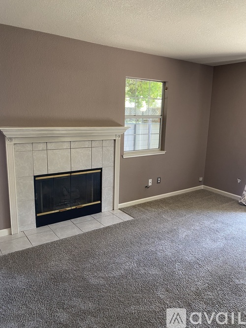 A room with a fireplace and a window.
