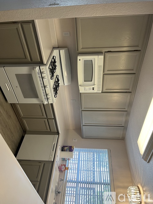 A view of a kitchen with a stove top oven and a microwave.