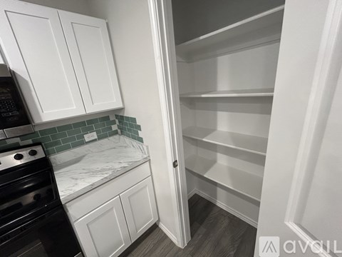 A kitchen with white cabinets and a black stove.