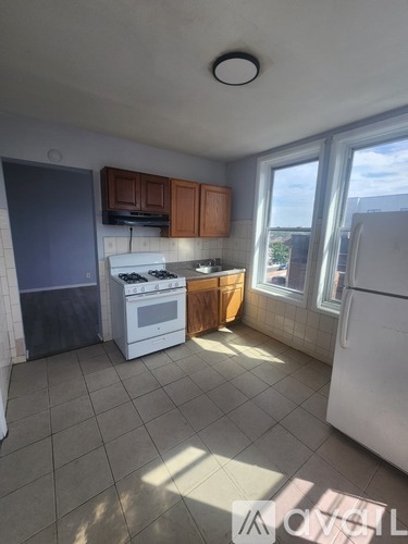 A kitchen with white appliances and brown cabinets.