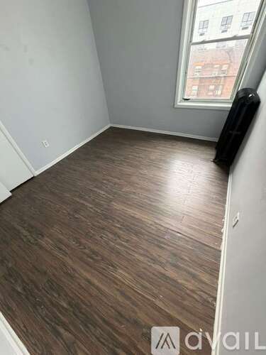 A room with wooden flooring and a window.