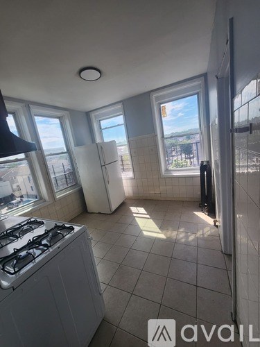 A kitchen with a stove and a window overlooking the outside.
