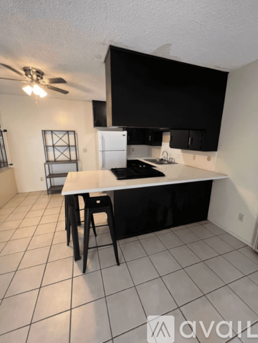 A kitchen with black cabinets and a white countertop.