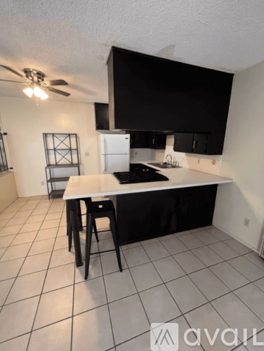 A kitchen with black cabinets and a white countertop.