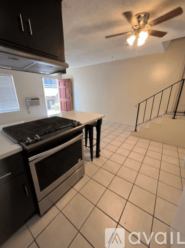 A kitchen with black cabinets and a stove top oven.