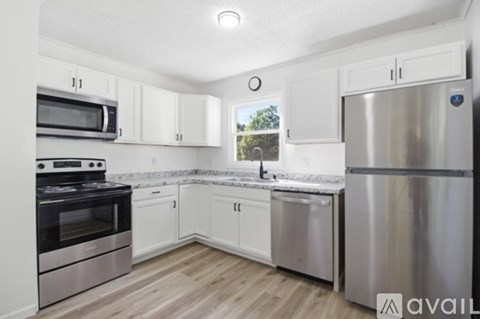 A kitchen with white cabinets and stainless steel appliances.