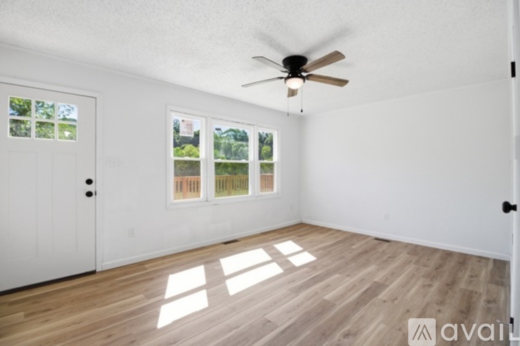 A room with a ceiling fan and a door leading to a balcony.