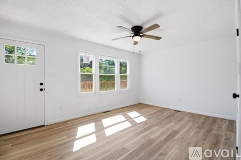 A room with a ceiling fan and a door leading to a balcony.