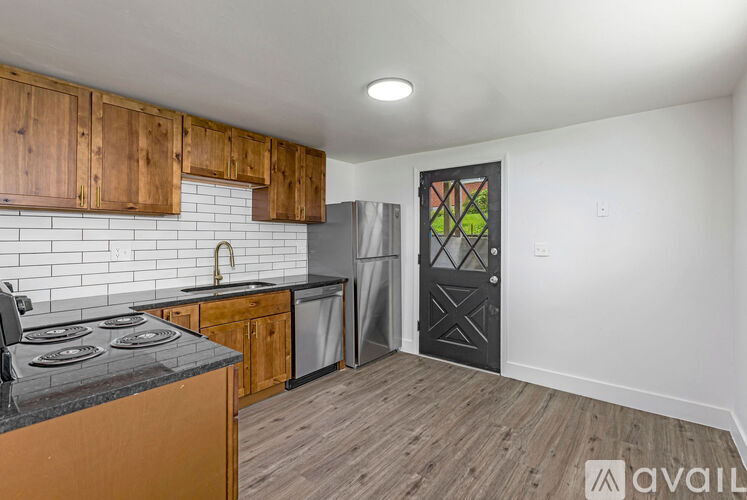 A kitchen with wooden cabinets and a black stove top oven.