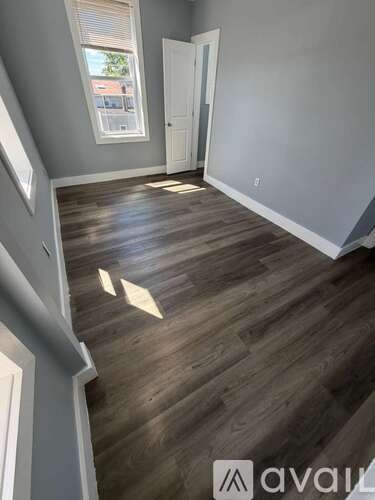 A room with wooden flooring and a window.