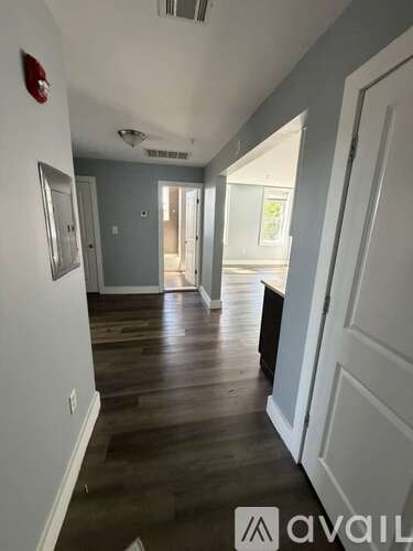 A hallway with wood floors and white walls.