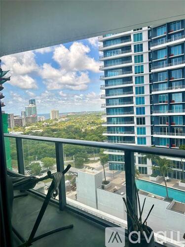 A balcony with a view of a cityscape and a pool.