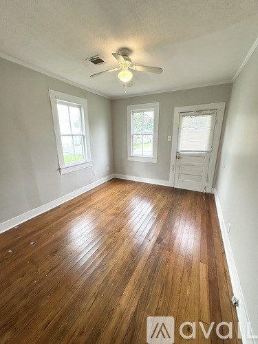A room with wooden floors and a ceiling fan.