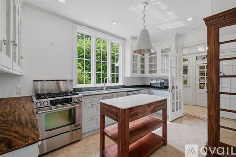 A kitchen with white cabinets and a wooden island.
