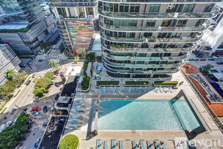 A tall building with a pool in front of it.