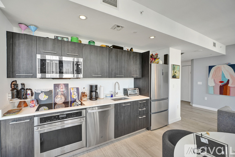 A modern kitchen with dark wood cabinets and stainless steel appliances.
