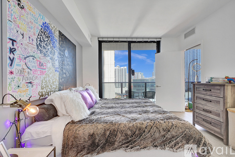 A bedroom with a large bed and a wall covered in graffiti.