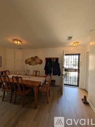 A dining room with a wooden table and chairs.