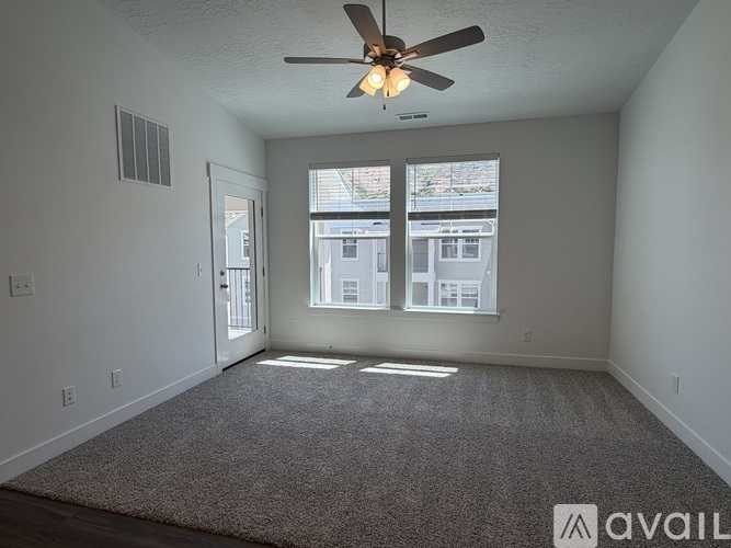 A room with a ceiling fan and carpeted floor.