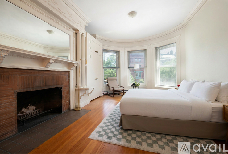 A bedroom with a fireplace and a large bed.