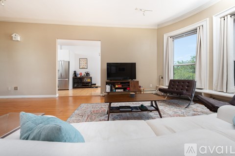 A living room with a white couch and a television.
