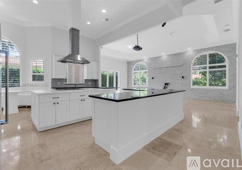 A modern kitchen with white cabinets and a central island.