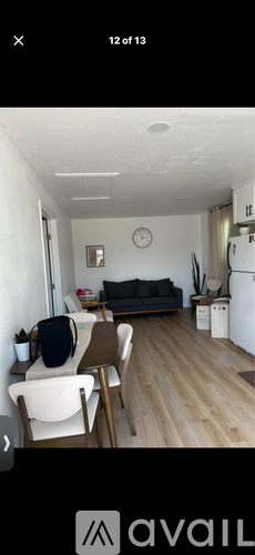 A living room with a couch, chair, and a clock on the wall.