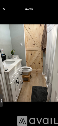 A bathroom with a wooden door and a white sink.