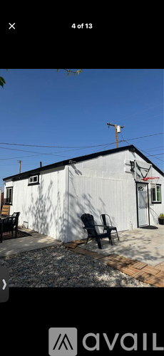 A white building with a black door and a small antenna on top.