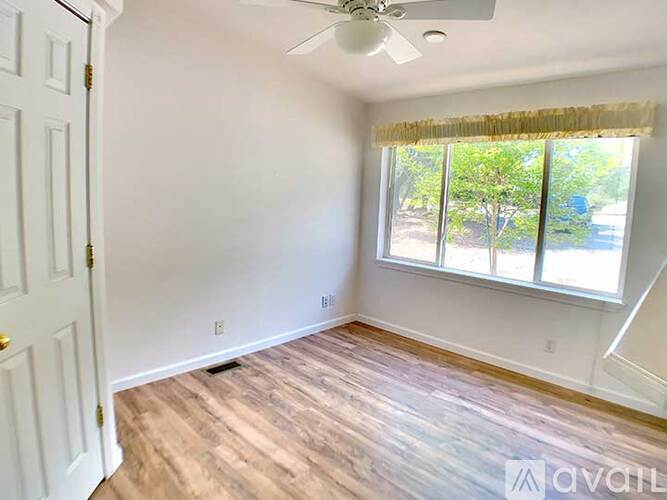A room with a window and a ceiling fan.