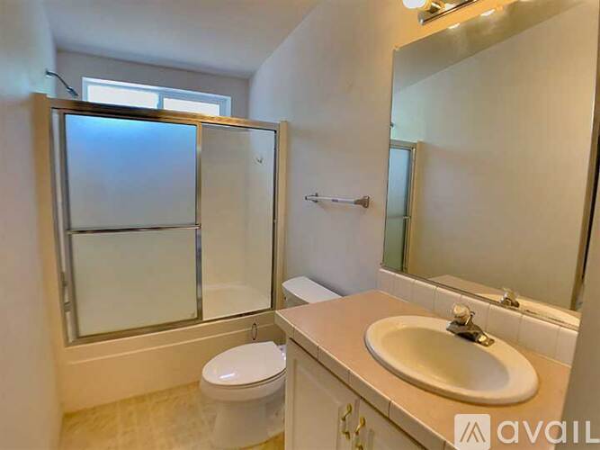 A bathroom with a toilet, sink, and shower.