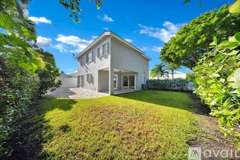 A white house with a green lawn in front.
