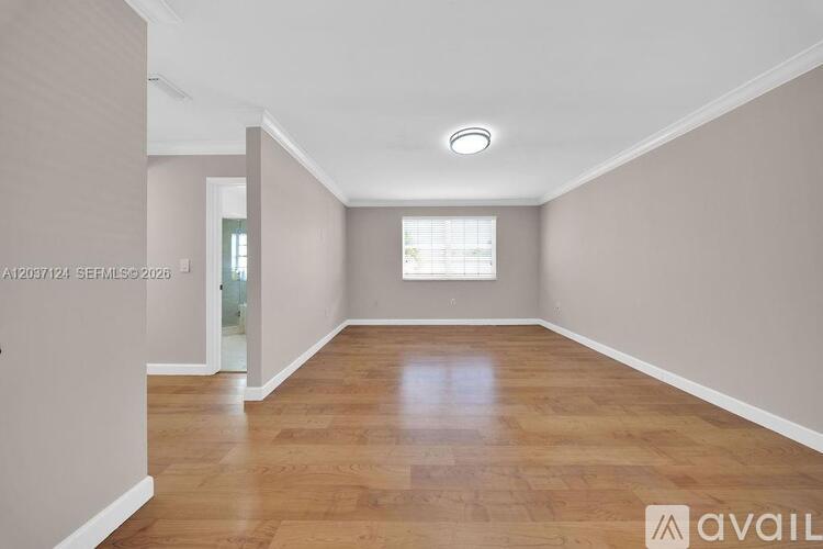 A room with wooden flooring and a window.