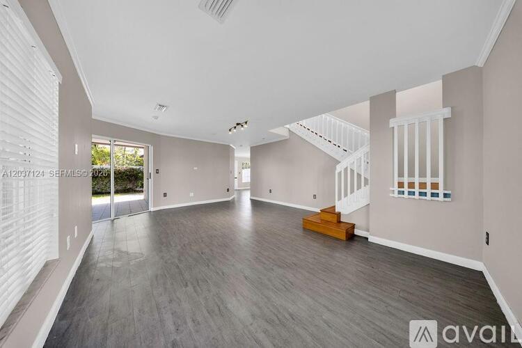 A spacious living room with a staircase leading to the upper floor.