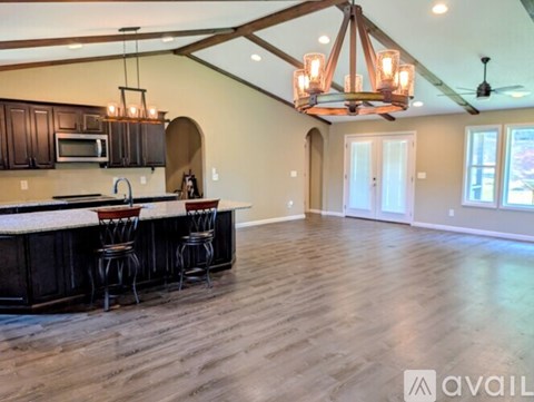 A kitchen with dark wood cabinets and a white countertop with a bar area.