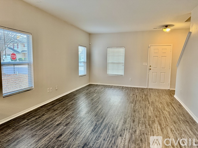 A room with wooden flooring and a white door is available for rent.