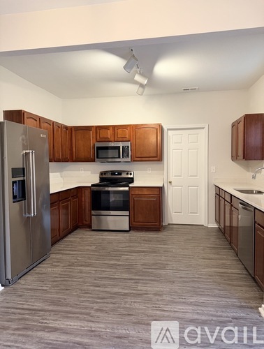 A kitchen with a refrigerator, microwave, oven, and sink.