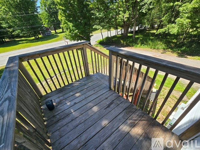 A wooden deck with a railing and a black object on it.