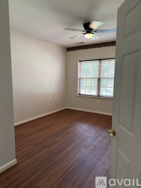 A room with a ceiling fan and a door.