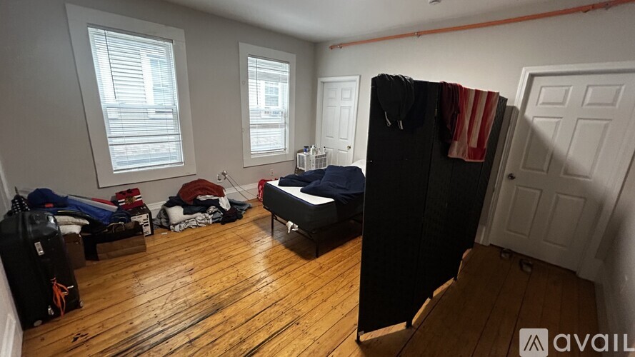 A room with a bed, wardrobe, and a window.