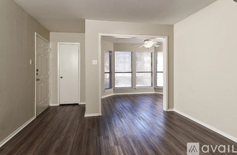 A room with wood flooring and a ceiling fan.