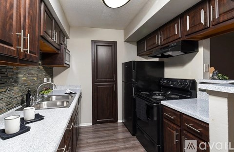 A kitchen with a black oven and wooden cabinets.