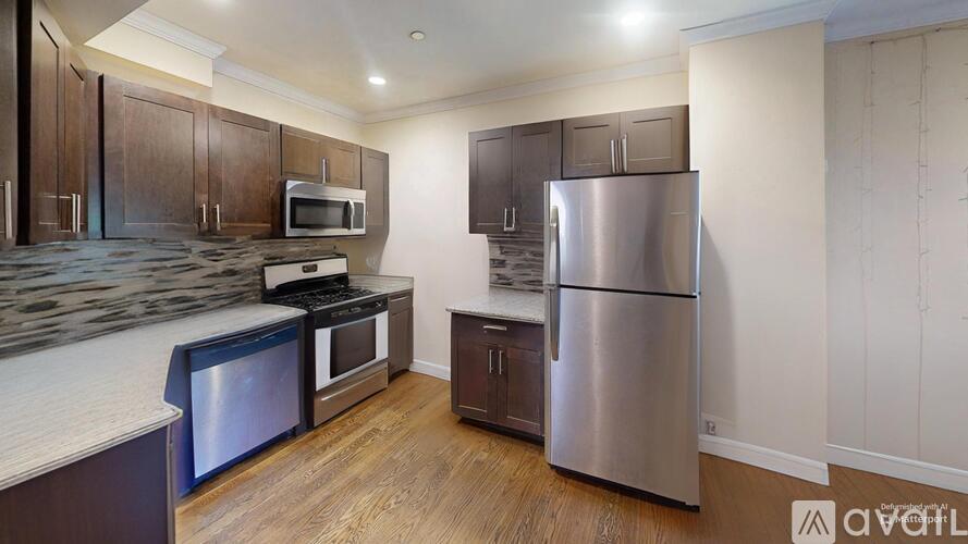 A kitchen with a refrigerator, microwave, oven, and stove.